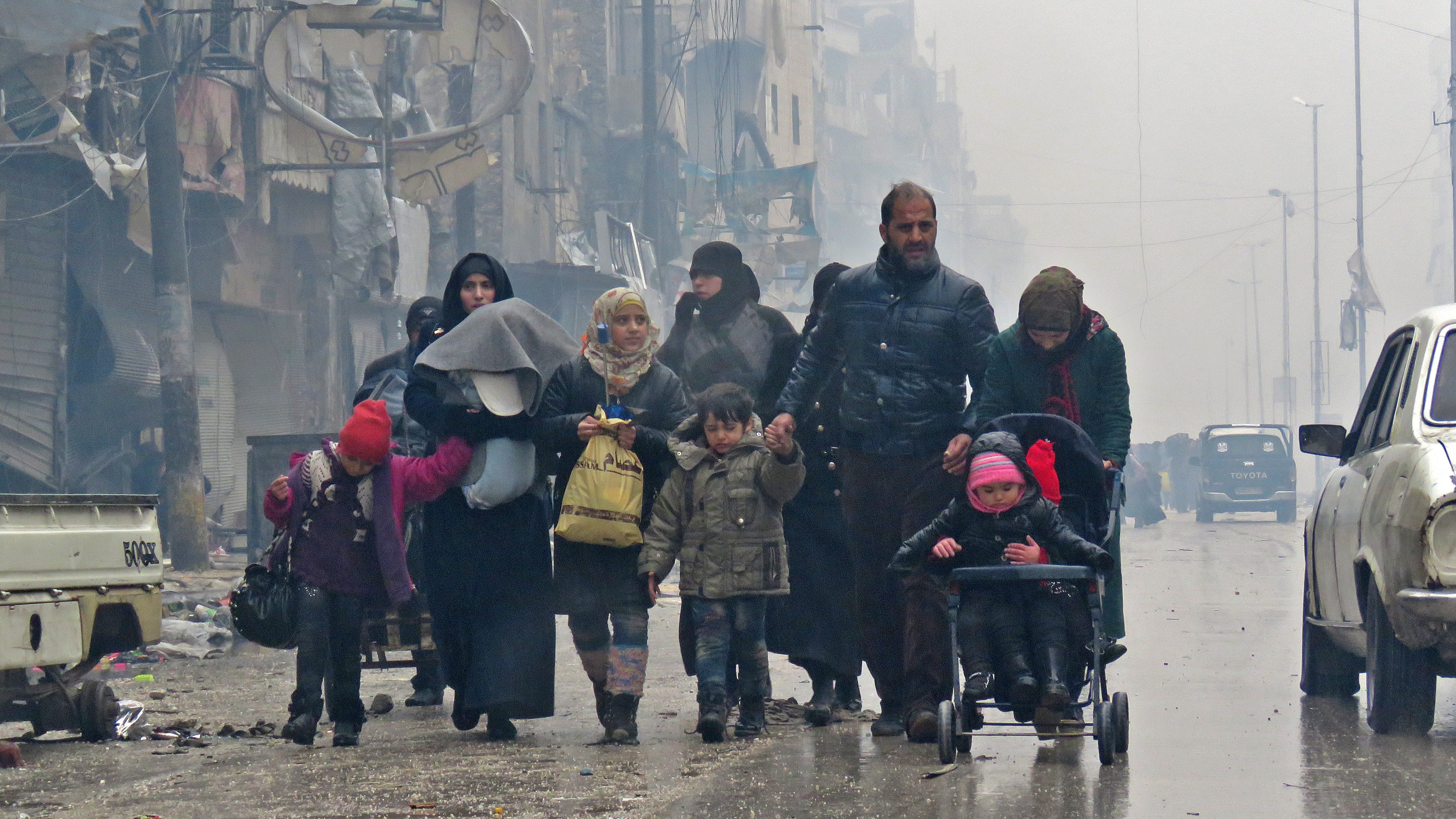 Syrian residents, fleeing violence in the restive Bustan al-Qasr neighbourhood, arrive in Aleppo's Fardos neighbourhood. Image credit: AFP Syrian residents, fleeing violence in the restive Bustan al-Qasr neighbourhood, arrive in Aleppo's Fardos neighbourhood. Image credit: AFP